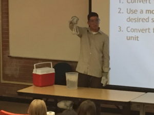 Person holds chemistry beaker with tongs