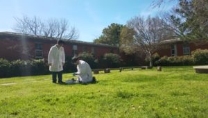 two people around an experiment in the grass